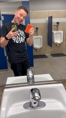 Customer holding the orange cleaning pad beside a bathroom mirror