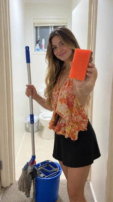 Customer holding the orange cleaning pad with a mop and bucket nearby